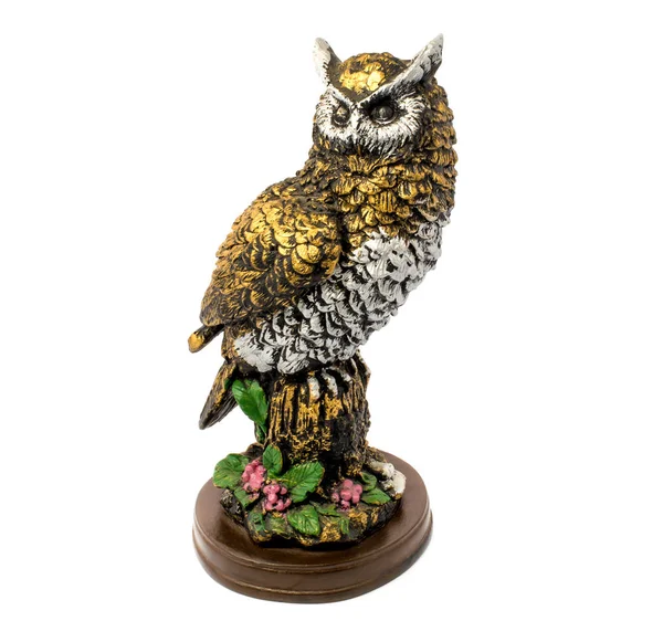 Çiçekli beyaz bir arka plan üzerinde izole altın baykuş heykelciği