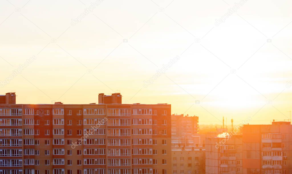 Photo of sunset over buildings in a warm light color tone at spring