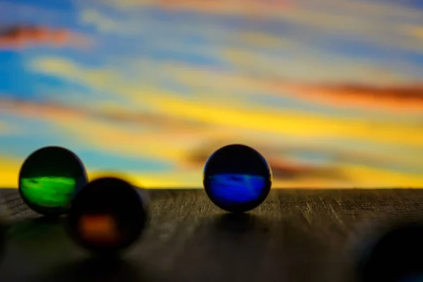 Foto de muchas bolas de vidrio sobre tabla de madera sobre fondo borroso — Foto de Stock
