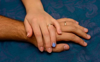 Fotoğraf el ile mavi arka plan üzerinde güzel alyans