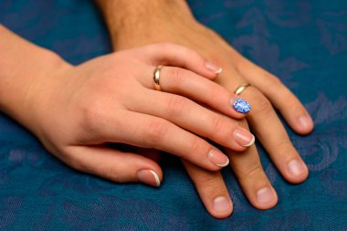 Fotoğraf el ile mavi arka plan üzerinde güzel alyans