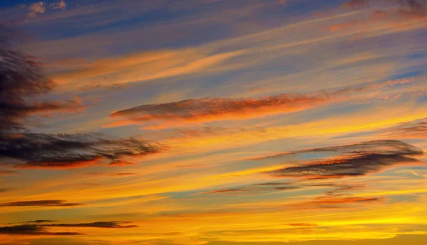 Фото оранжевого заката с темными облаками на небе — стоковое фото