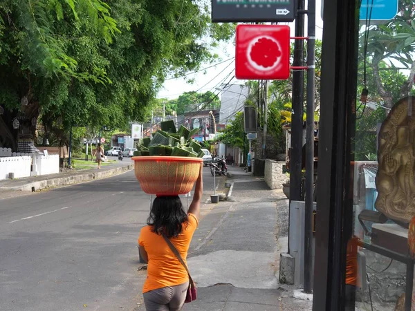 Una dama lleva hojas de plátano en la calle Sanur Danau Tamblingan —  Fotos de Stock