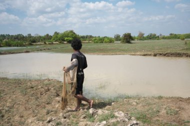 Kampong Thom, Kamboçya-25 Ocak 2020: Kamboçya, Kamboçya 'da Sambor Prei Kuk yakınlarında 219 numaralı otoyol boyunca ağ atan bir adam