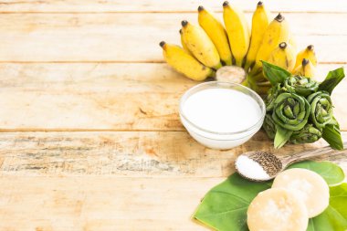 Olgun muz tatlısı ahşap arka planda Hindistan cevizi sütü ve şeker ve tuz gibi doğanın hammadde var. Üst görünüm ve yakın çekim