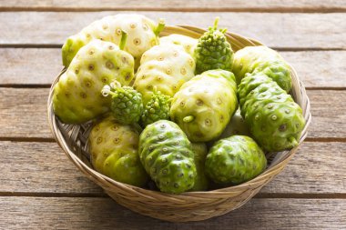 Noni meyve sepeti ahşap masa üzerinde. Meyve sağlık ve bitki sağlığı için