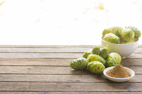 Noni frutas e noni pó em mesa de madeira.Frutas para a saúde e ervas para a saúde — Fotografia de Stock