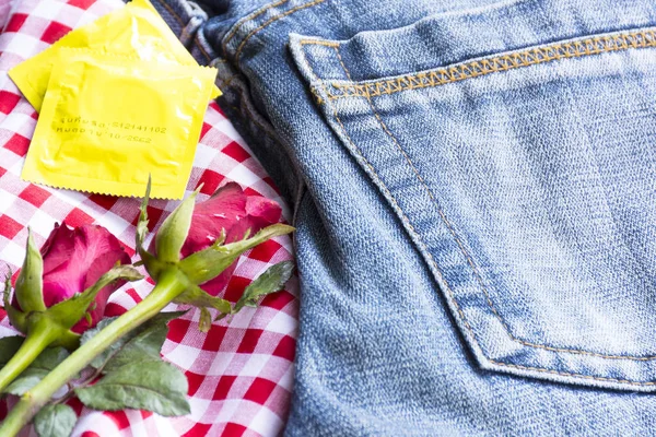 Пакувати презервативи з трояндами та джинсами. Секс або історія Валентина день. Закрити — стокове фото