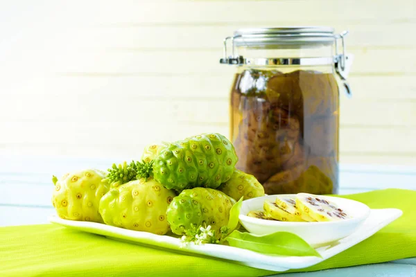 Yemek ve noni dilim ile yeşil kareli kumaş üzerine fermente noni Noni meyve