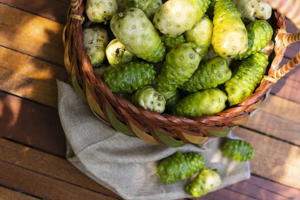 Noni Keranjang Dan Noni Pada Brown Kain Atas Meja Kayu — Stok Foto