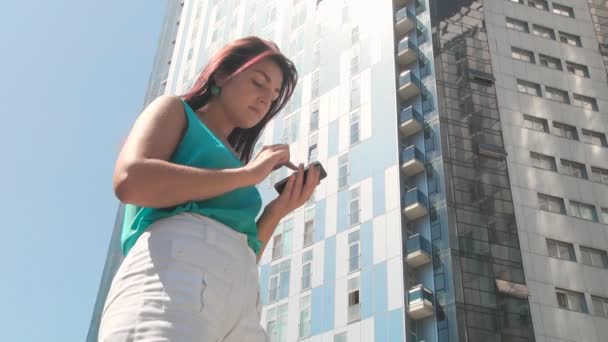 Menina com um smartphone na cidade — Vídeo de Stock