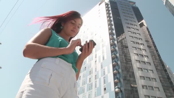 Mädchen mit Smartphone in der Stadt — Stockvideo