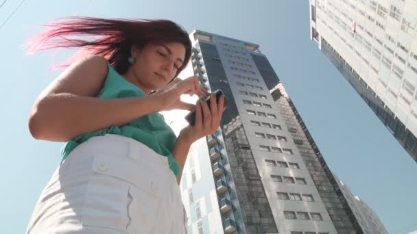 Дівчина зі смартфоном у місті — стокове відео