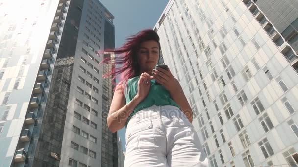 Девушка со смартфоном в городе — стоковое видео