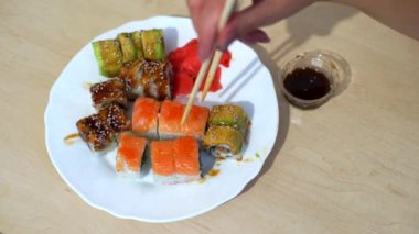 Bir kadın suşi yiyor ve rulolar