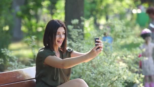 Девушка делает селфи в парке — стоковое видео