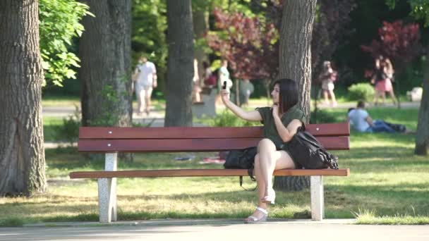 Dívka, která dělá selfie v parku — Stock video