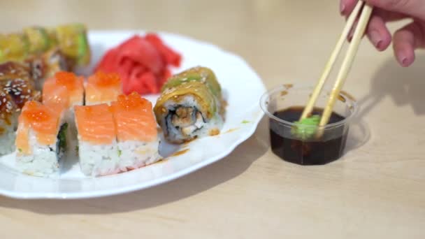 A woman eats sushi and rolls — Stock Video