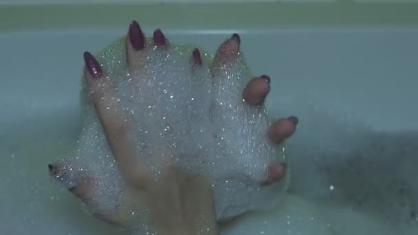 Shampooing mousse dans les mains Belle femme se baignant dans la salle de bain en jouant avec de la mousse dans ses mains est sorti du shampooing 