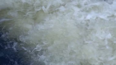 Suyun yavaş akışı. Rezervuardan büyük miktarda su akıyor. Su kütlesi kaynar ve köpükler güçlü bir akış yaratır..