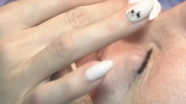 Kaş güzellik salonunda, üstat kaşlarla ilgilenir. Kadın kaşlarının tasarımı ve boyaması ve kaplaması. Renk eşleşmesi. Kozmetik bir araçla düzeltme.