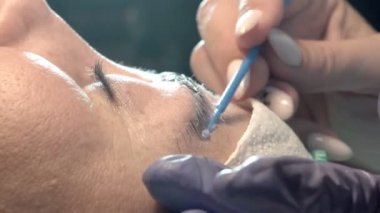 Kaş güzellik salonunda, üstat kaşlarla ilgilenir. Kadın kaşlarının tasarımı ve boyaması ve kaplaması. Renk eşleşmesi. Kozmetik bir araçla düzeltme.