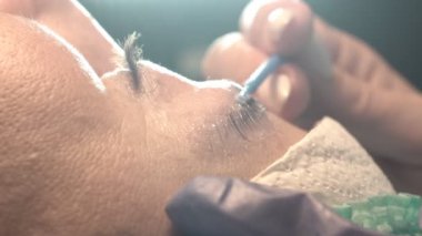 Kaş güzellik salonunda, üstat kaşlarla ilgilenir. Kadın kaşlarının tasarımı ve boyaması ve kaplaması. Renk eşleşmesi. Kozmetik bir araçla düzeltme.