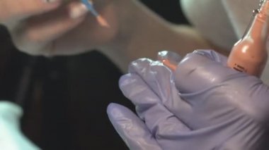 Kaş güzellik salonunda, üstat kaşlarla ilgilenir. Kadın kaşlarının tasarımı ve boyaması ve kaplaması. Renk eşleşmesi. Kozmetik bir araçla düzeltme.