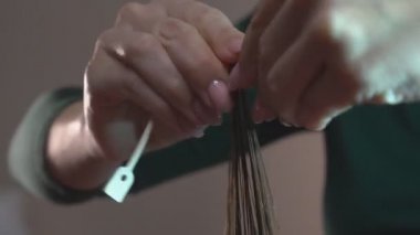 Kıvırcık saçlı. Kuaför, bir kuaförde saçlarını tarayıp kıvırtarak bir çocuk için saç stili yapar..