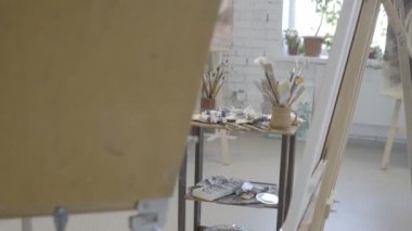 Resim için fırça yapan bir sanatçı. Fırça ve sehpanın boyayla boyanması için hazırlanması