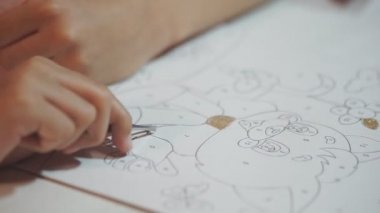 Parlak pudrayla çocuk resimleri yapar. Çocuk kağıt çizimlerini parlak tozla boyuyor, yapıştırıcıya dayanarak küçük parıltıları ovuyor. Çocukların yaratıcılığını geliştirir.