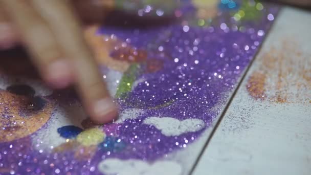 光沢のある粉で子供の塗料 子供は光沢のある粉末で紙の図面をペイントし 接着剤に基づいて小さなグリッターをこすります 子供の創造性を育てる — ストック動画