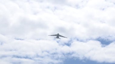 Uçak mavi gökyüzüne doğru havalanıyor. Büyük bir kargo uçağı uçurmak köyün yüksekliğini düşürür.