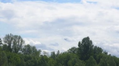 Uçak mavi gökyüzüne doğru havalanıyor. Büyük bir kargo uçağı uçurmak köyün yüksekliğini düşürür.