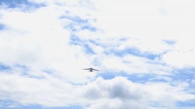 Uçak mavi gökyüzüne doğru havalanıyor. Büyük bir kargo uçağı uçurmak köyün yüksekliğini düşürür.