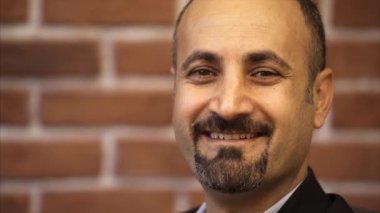 Adam Studio kameraya bakıyor ve gülümsüyor