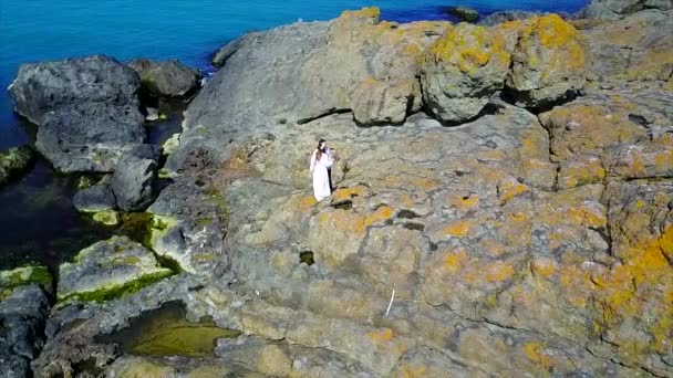 Aérea de pareja en acantilado junto al mar — Vídeo de stock