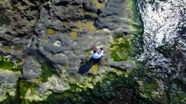 Aerial Of Couple On Cliff next to sea — Stock Video