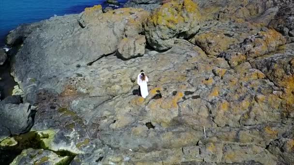 Aérea de pareja en acantilado junto al mar — Vídeos de Stock