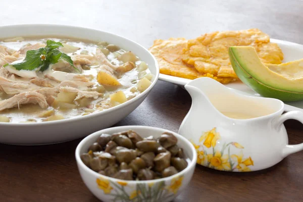 Ajiaco served with patacon, avocado and capers — Stock Image Ajiaco served with patacon, avocado and capers Stock Image