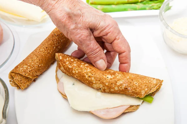 Die gefüllten Quinoa-Crêpes aufrollen — Stockfoto