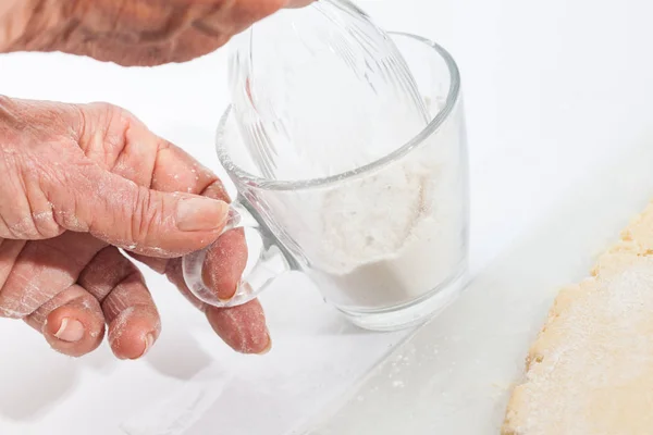 Lägga till mjöl i glaskanten att skära degen — Stockfoto