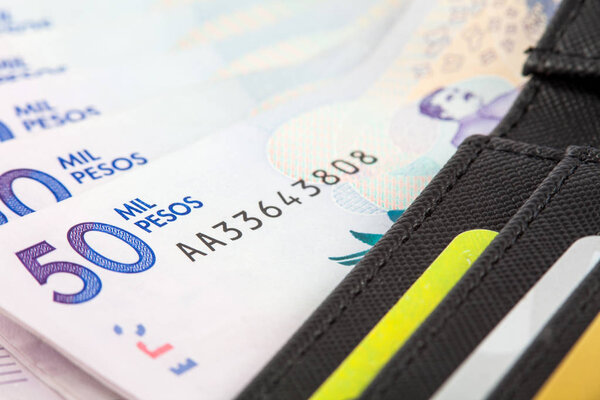 Чёрный бумажник, набитый деньгами и карточками
