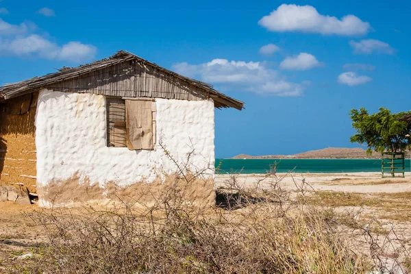 Casa de adobe tradicional ao lado do mar sob o céu azul — Fotografia de Stock