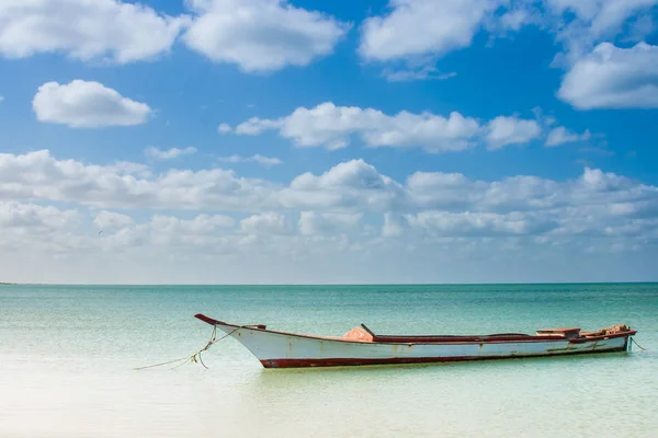Canoa flotando en aguas tranquilas bajo el hermoso cielo azul — Foto de Stock