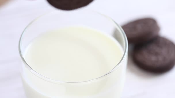 Женщина макает шоколадное печенье в молоко — стоковое видео
