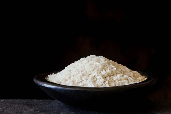 전통적인 검은색 클레이 접시에 원시 쌀 곡물 — 스톡 사진