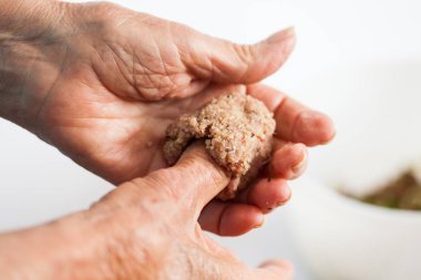 Bir kadın kıdemli elinde bir İçli köfte şekillendirme yakın çekim
