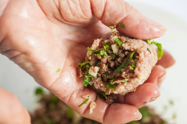 Cierre de manos de una mujer mayor llenando un kibbeh — Foto de Stock