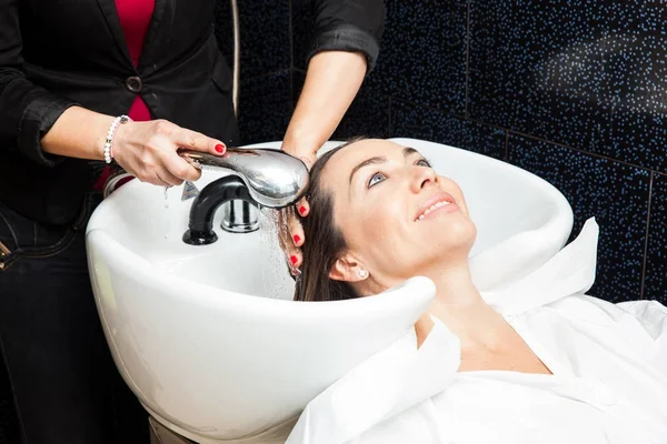 Mujer blanca lavándose el pelo en un salón de belleza —  Fotos de Stock